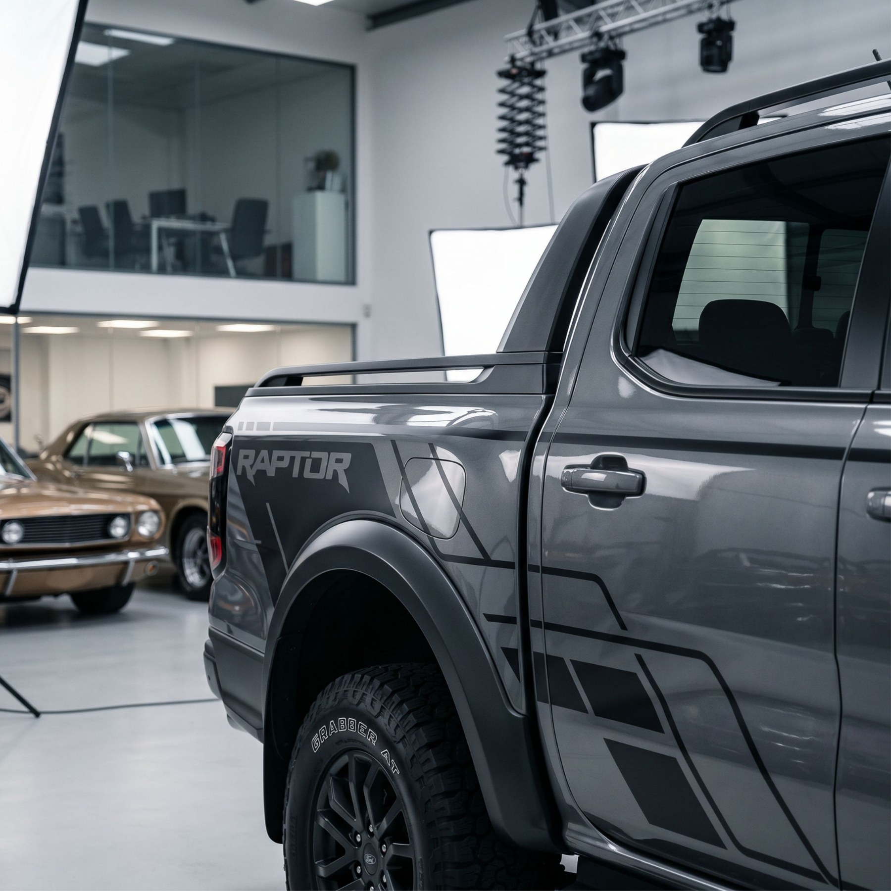 Dark grey pickup with black geometric side graphics in a studio
